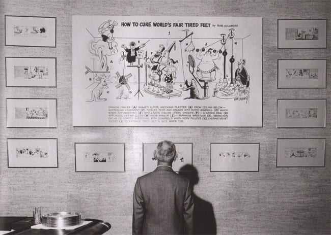 Rube Goldberg stands before a display of his art at the 1964-65 New York World's Fair. 